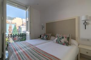 圣克鲁斯-德拉帕尔马Hotel Emblemático Holiday Time的一间卧室设有两张床和大窗户
