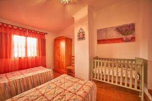 丰特埃里多斯VILLA IRENE的一间卧室配有两张单人床和一张婴儿床。