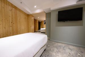 碧瑶G1 Lodge的一间卧室配有一张床和一台平面电视