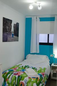 TigadayV.V. Casa Quintero的一间卧室配有一张蓝色墙壁的床