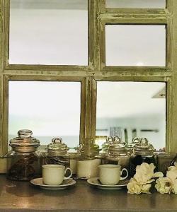 弗朗斯胡克Willow Brooke Guest Suite的窗户,桌子上放着杯子和碟子