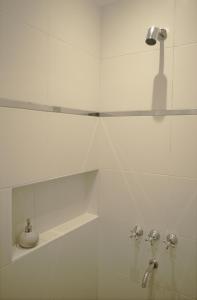 萨尔塔Casa Bordó Salta的带淋浴和盥洗盆的白色瓷砖浴室