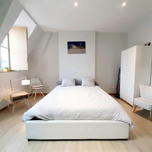 第戎Studio Jean LEBELIN的卧室配有白色的床和椅子