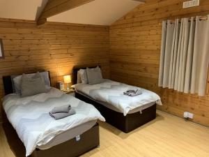 迪德科特Southernwood - Garden Lodge 2的木墙客房的两张床