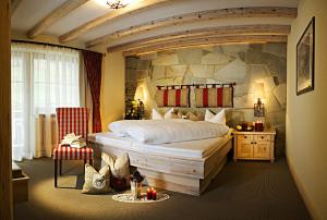 伊施格尔蒙塔纳拉酒店的一间卧室设有一张带石墙的大床