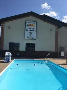 CassvilleCassville Four Seasons Inn & Suites的一座带标志的建筑前的游泳池