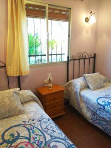 隆达Casa Rural Bellavista Ronda的一间卧室设有两张床和窗户。