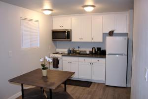 西雅图Rainier Guesthouse (Walk to Metro)的厨房配有桌子和白色冰箱。