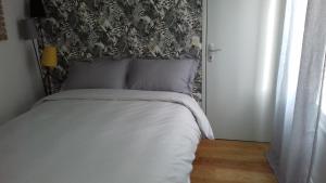 特鲁瓦Duplex La Maisonnette 2 Chambres - parking gratuit的一间卧室配有一张带黑白床头板的床