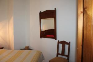 卡皮雷拉Apartamentos Rurales Rosendo: La Orquídea的卧室配有一张床,墙上设有镜子