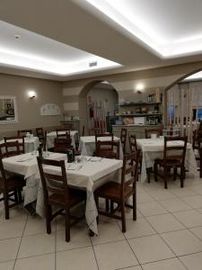 科斯特曼诺Albergo Villa Eva的用餐室配有白色的桌子和木椅