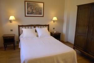 布尔马当萨利苏尔酒店的一间卧室配有一张带2个床头柜的大型白色床