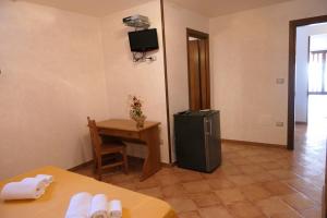 加利亚诺德尔卡波B&B Sentiero del Ciolo的客房设有小桌子和冰箱。