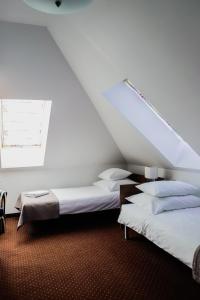 华沙卡利诺伊森酒店的带屋顶的客房内的两张床