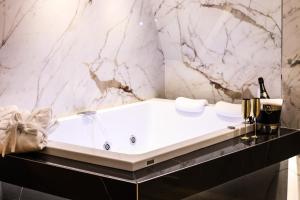 那不勒斯Municipio Luxury Suite的带浴缸的浴室和大理石墙
