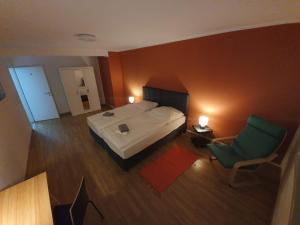 纽伦堡White Pearl Hostel 2的一间卧室配有一张床和一把绿色椅子