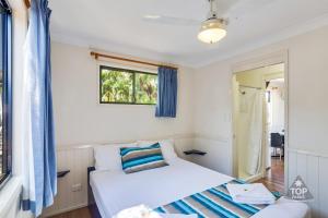 汤斯维尔珊瑚海岸观光假日公园的一间卧室设有两张床和窗户。
