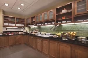 霍夫曼庄园Hyatt Place Chicago Hoffman Estates的厨房配有木制橱柜和柜台上的食品