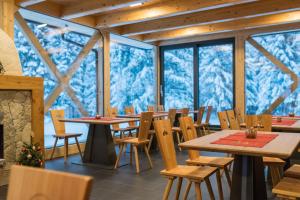 Zgornja SoricaGuesthouse Lajnar的用餐室设有桌椅和窗户。