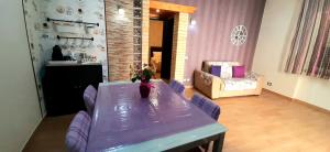夏卡Castello Apartment Deluxe的一间用餐室,配有一张紫色的桌子和椅子