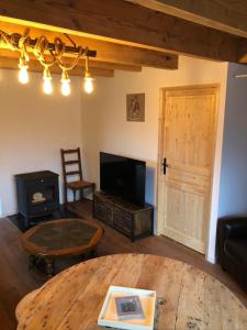 Saint-Apollinaire-de-RiasLa bergerie的客厅配有桌子、电视和燃木炉。