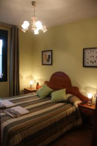厄尔巴拉克Hostal Maury的一间卧室配有一张大床和两盏灯
