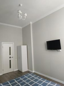 切尔诺夫策Apartmen28juni的客厅配有电视和白色墙壁。
