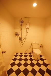 那空拍侬府Windsor Hotel的一间带卫生间和 ⁇ 格地板的浴室