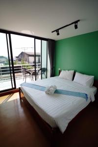 那空拍侬府Windsor Hotel的一间卧室设有一张大床和绿色的墙壁