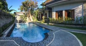 乌布Villa Dira Ubud的一座房子的院子内的游泳池