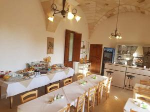 马尔塔诺Masseria Sucéa的配有桌椅的大房间和厨房