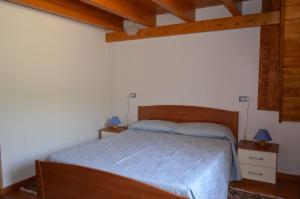 圣安蒂奥科Casa Vacanze Cala Sapone的一间卧室配有一张带蓝色床单和木制天花板的床。