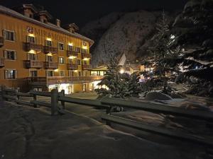 拉特乌伊莱Le Miramonti Hotel Restaurant & Wellness的夜间酒店,有圣诞树和栅栏