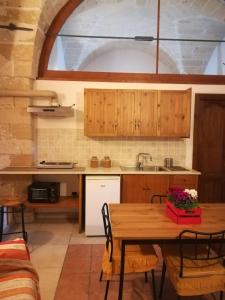 韦列Masseria Caracci的厨房配有木制橱柜和桌椅