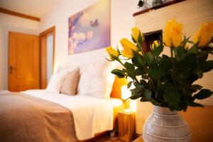 哈尔施塔特Apartments Marie A的卧室里一个满是黄色花的花瓶