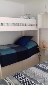里耶LES TILLEULS的一间卧室配有两张双层床和蓝色枕头