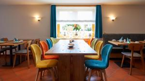 莱茵河畔因格尔海姆费特泽斯兰德酒店的餐厅配有木桌和椅子