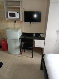 内罗毕Nairobi west suite的客房设有书桌、微波炉和电脑