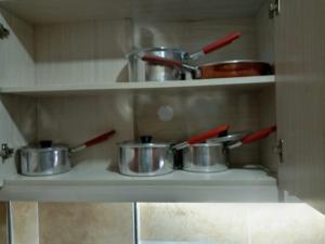 内罗毕Nairobi west suite的厨房里摆放着锅碗瓢盆的架子