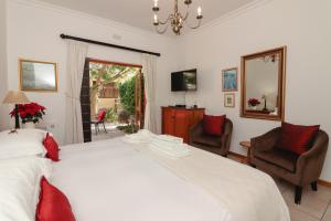 钓鱼镇托斯卡纳风格别墅旅馆的卧室配有一张白色大床和两把椅子
