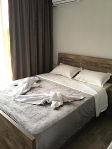 乌雷基Cottages Ureki的一张配有白色床单和枕头的大床
