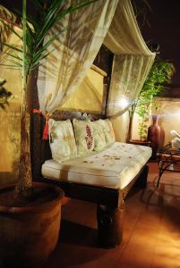 马拉喀什里亚德画廊49号庭院旅馆的配有窗帘和枕头的宿舍间内的一张床位