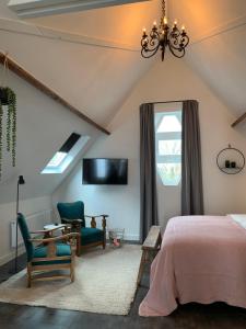 芬洛De Vossenheuvel的一间卧室配有一张床、一把椅子和电视。