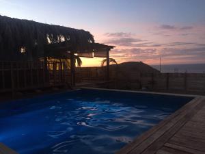 曼克拉Teulu的蓝色的游泳池,背面是日落