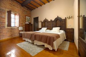 Esposende卡萨都乌略亚酒店的一间卧室设有一张大床和砖墙