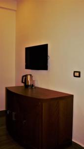 安曼New MerryLand Hotel的一间设有壁挂式电视和木柜的房间