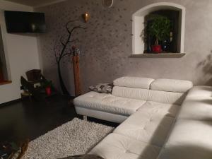 努斯Villa La Tour的客厅配有白色沙发和吉他