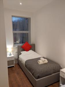 特伦特河畔斯托克Modern Newgate Apartments - Convenient Location, Close to All Local Amenities的一间卧室配有一张红色枕头的床