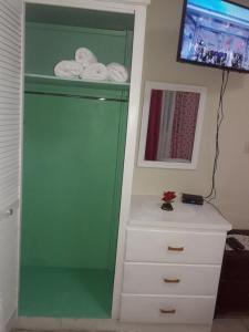 卡斯特里山景旅馆的白色梳妆台旁的绿色橱柜,配有毛巾