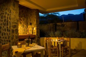 波特雷里约斯Las Espuelas Casas de Montaña的餐厅设有两把桌子和椅子,设有窗户